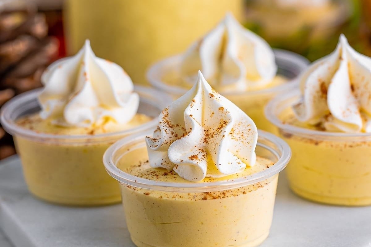 Mini pumpkin cheesecakes topped with whipped cream.