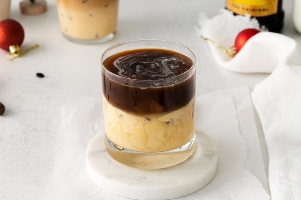 A cup of coffee with whipped cream and chocolate syrup, perfect for a festive eggnog recipe.