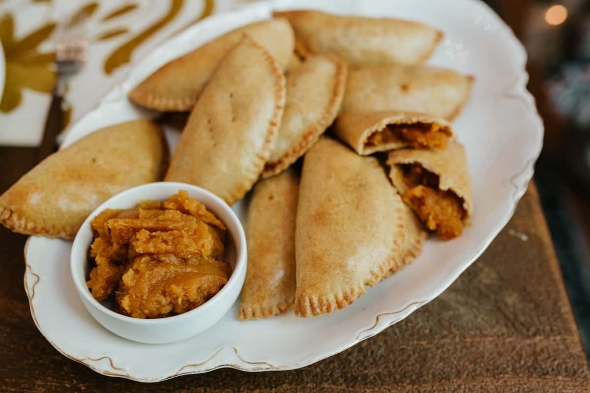 Make ahead holiday pumpkin empanadas on a plate with dipping sauce.