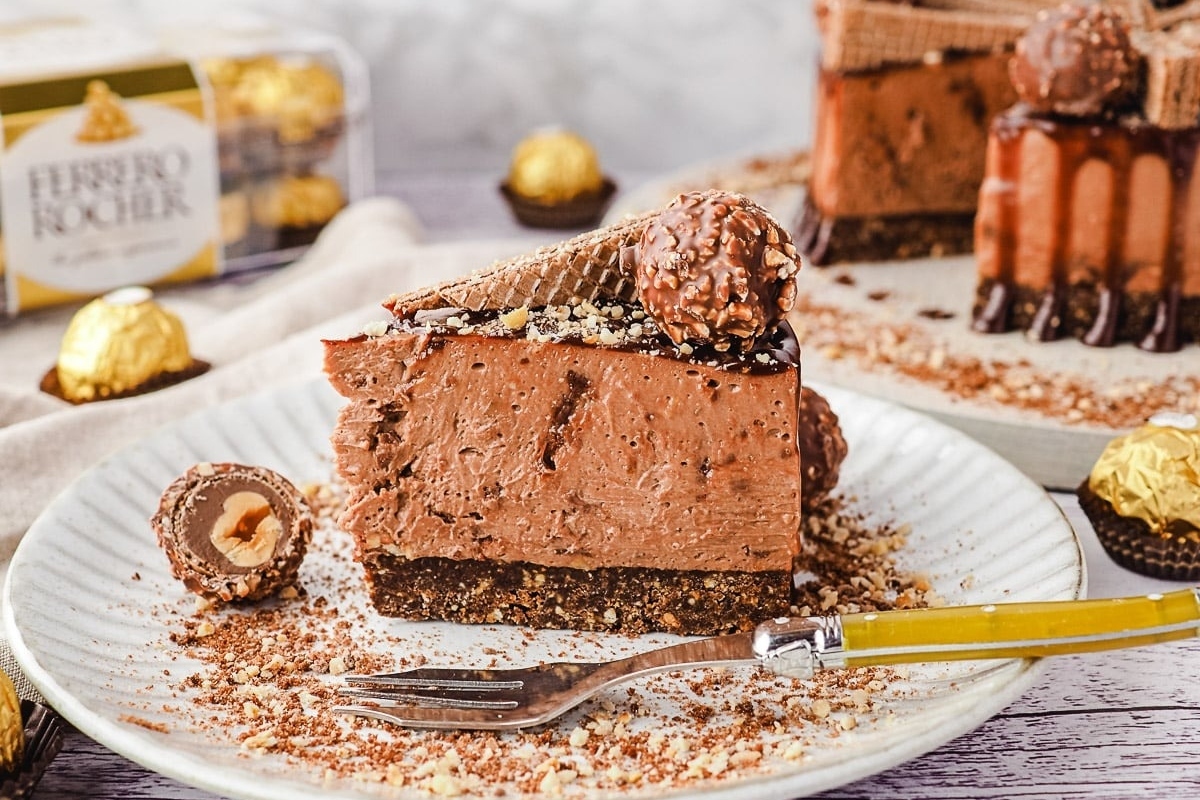 A decadent piece of chocolate cake on a festive plate with a fork, perfect for indulging in no bake Christmas desserts.