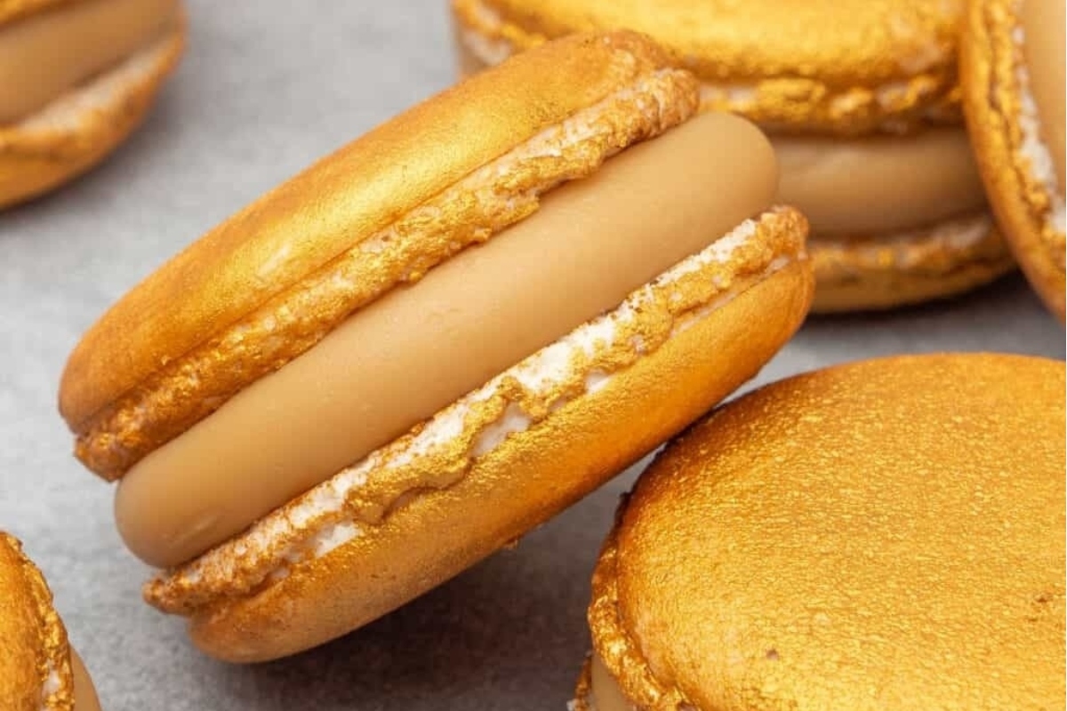 A group of gold macarons displayed on a table at a New Year's Eve party.