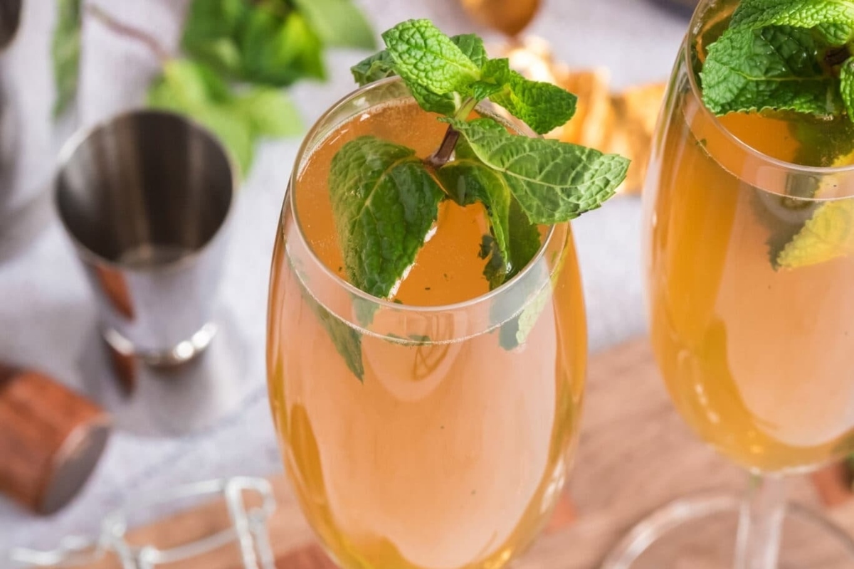 Two glasses of champagne with mint leaves in them, perfect for a New Year's eve party.