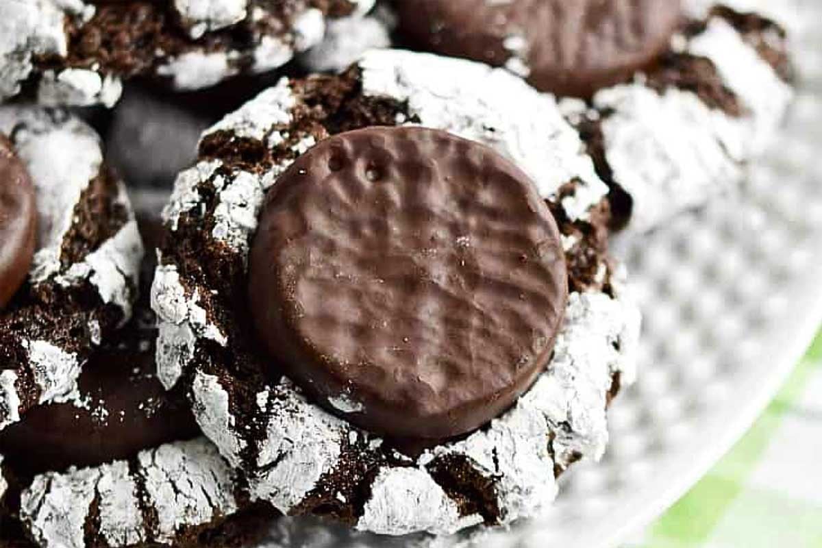 Crinkle cookies on a plate with powdered sugar.