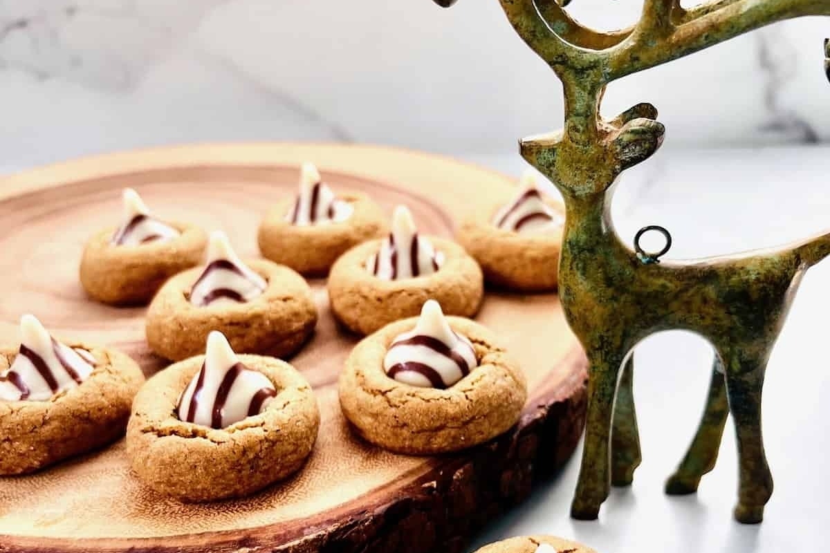Cookies on a wooden plate with a reindeer statue.