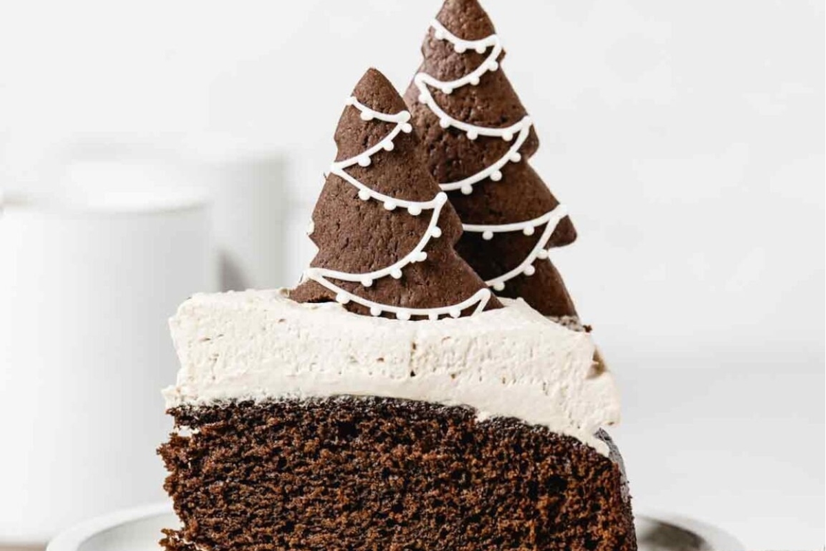 A festive Christmas cake adorned with a cookie-shaped tree, making it truly a piece of cake to create a delightful holiday treat.