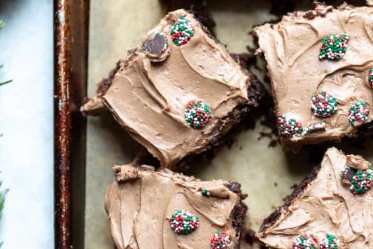 Christmas brownies with chocolate frosting on a baking sheet.