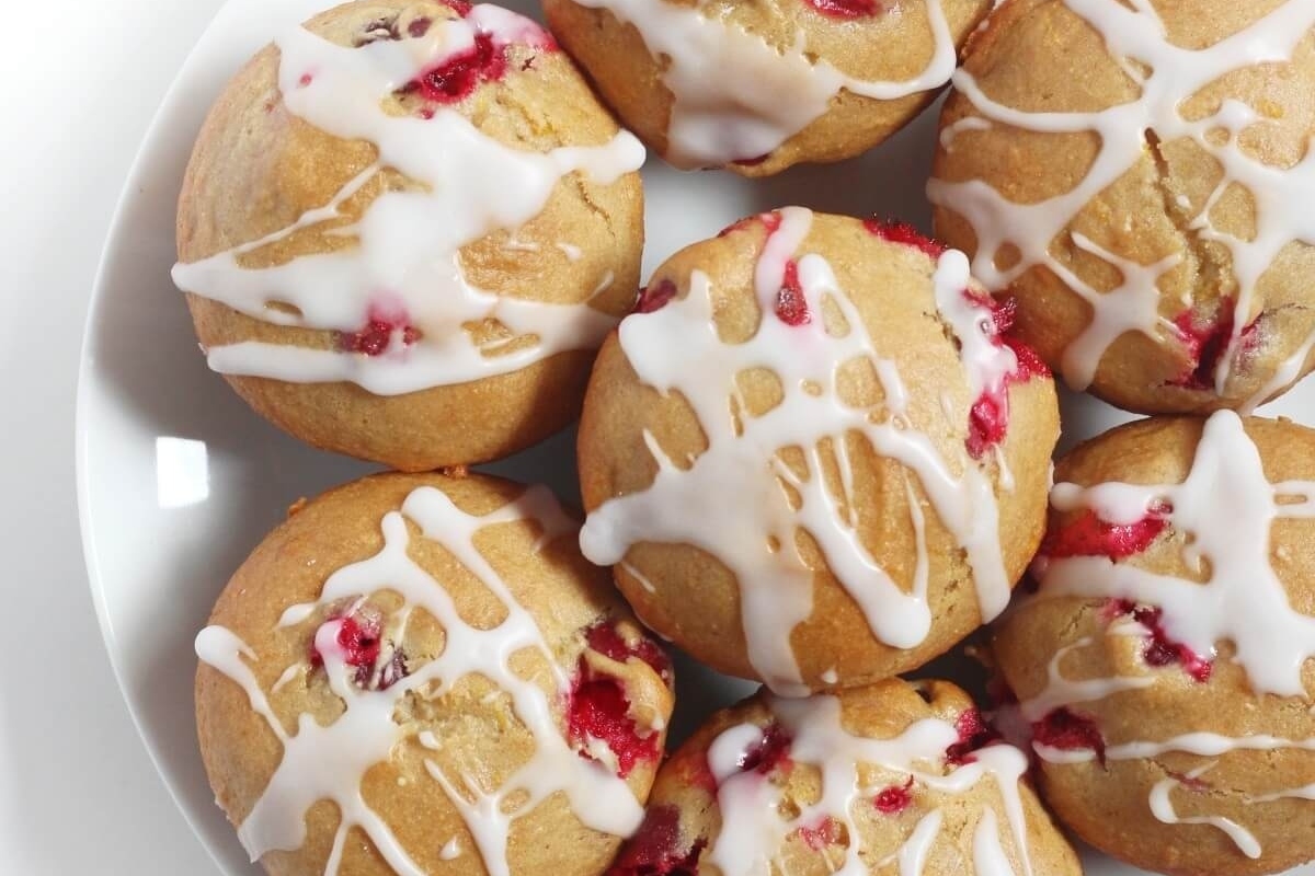 Cranberry muffins, a delightful cranberry snack recipe, topped with a delicious icing, beautifully displayed on a plate.