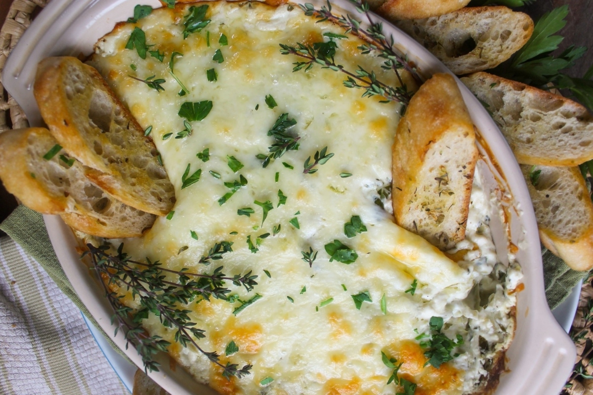 NYE appetizers: Cheesy spinach dip with croutons and bread.