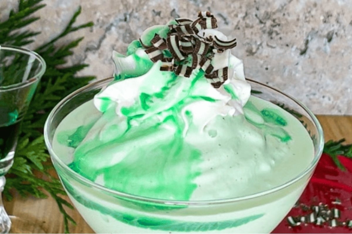 A green and white dessert with whipped cream and green sprinkles, perfect for Christmas.