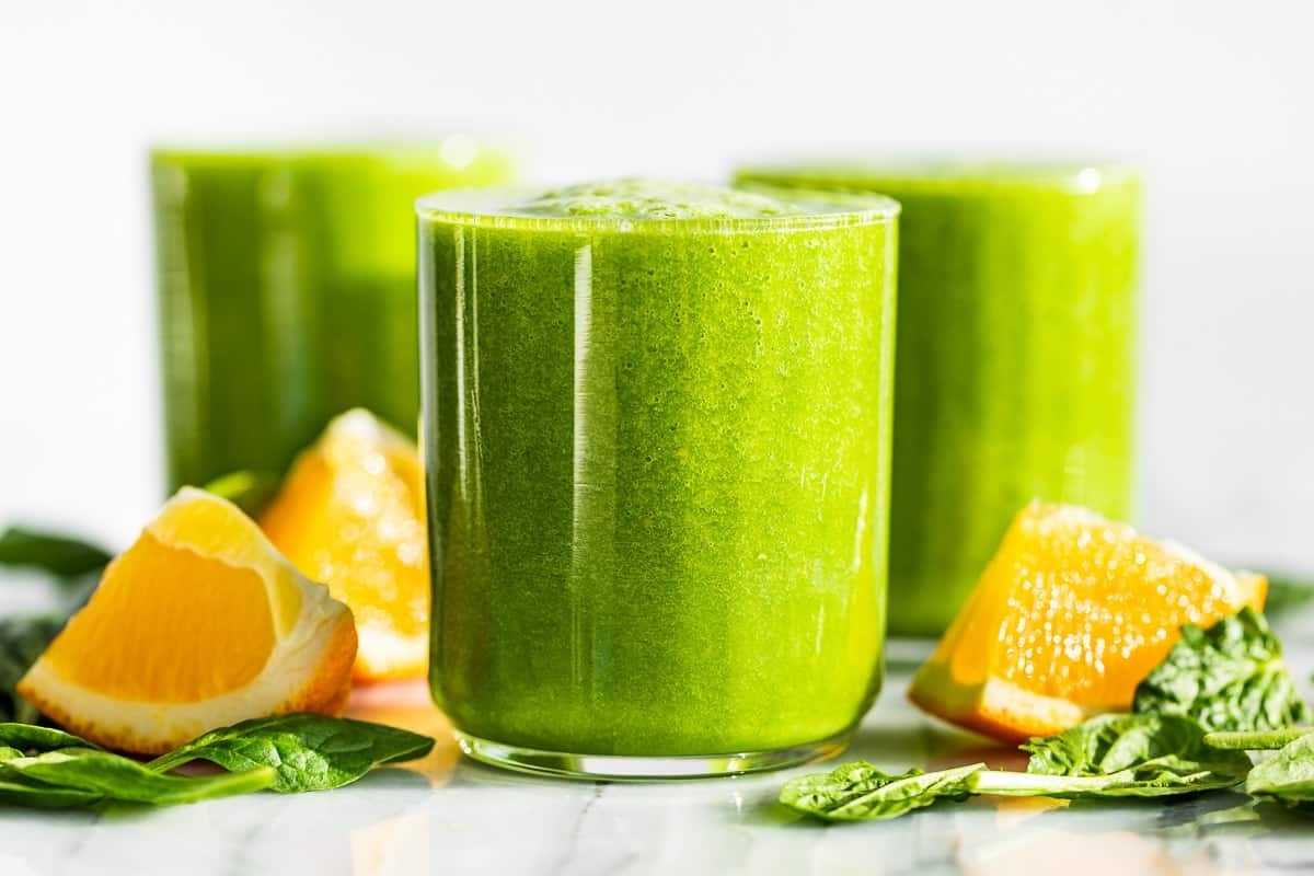 A refreshing green smoothie with vibrant orange slices and a minty twist.