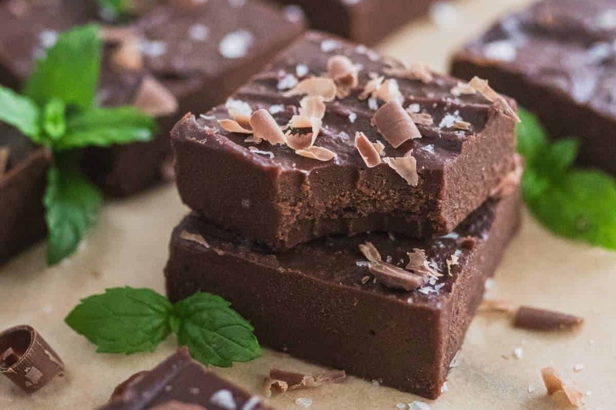 A stack of peppermint chocolate fudge with mint leaves on top.