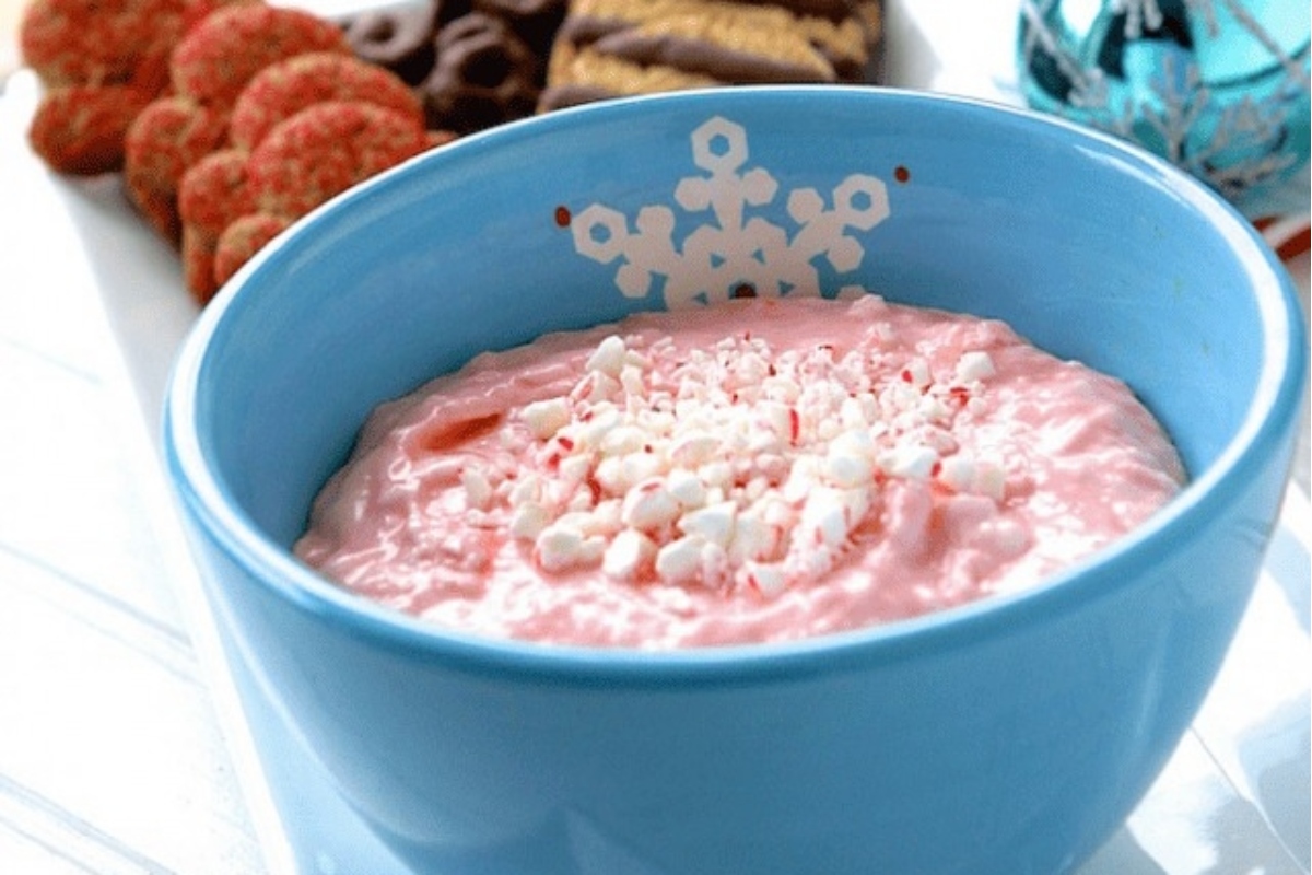 A blue bowl with whipped cream and peppermint cookies.