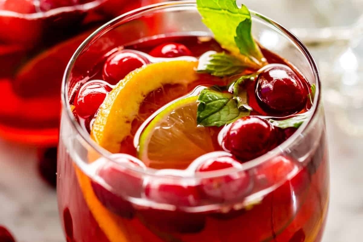 A festive glass of cranberry sangria infused with oranges and lemons, perfect for Christmas cocktails.