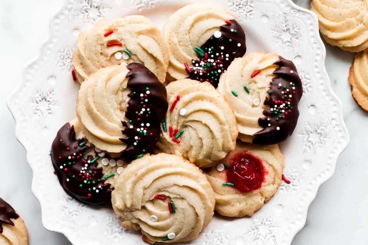 Christmas cookies on a white plate with chocolate icing ready for holiday gifting.