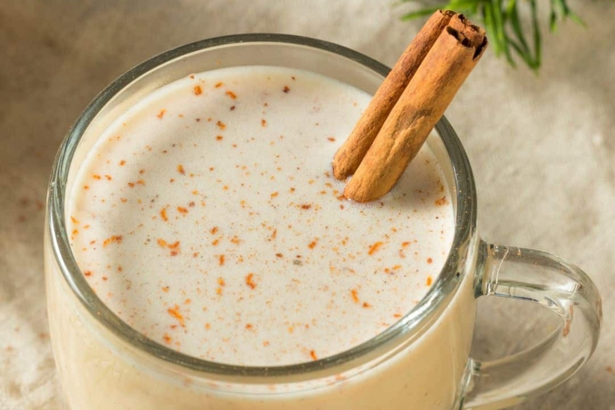 A mug with a cinnamon drink recipe and a cinnamon stick.