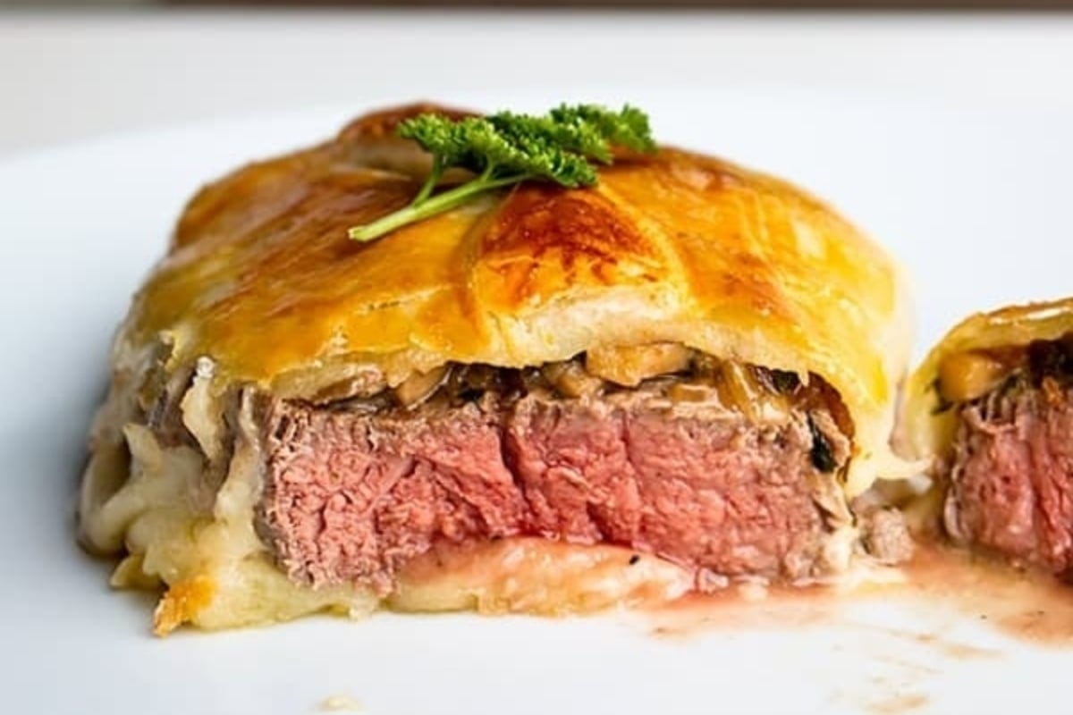 A flavorful dish featuring a succulent piece of beef stuffed with gourmet cheese and aromatic herbs, perfect for indulging in during festive New Year's dinners.