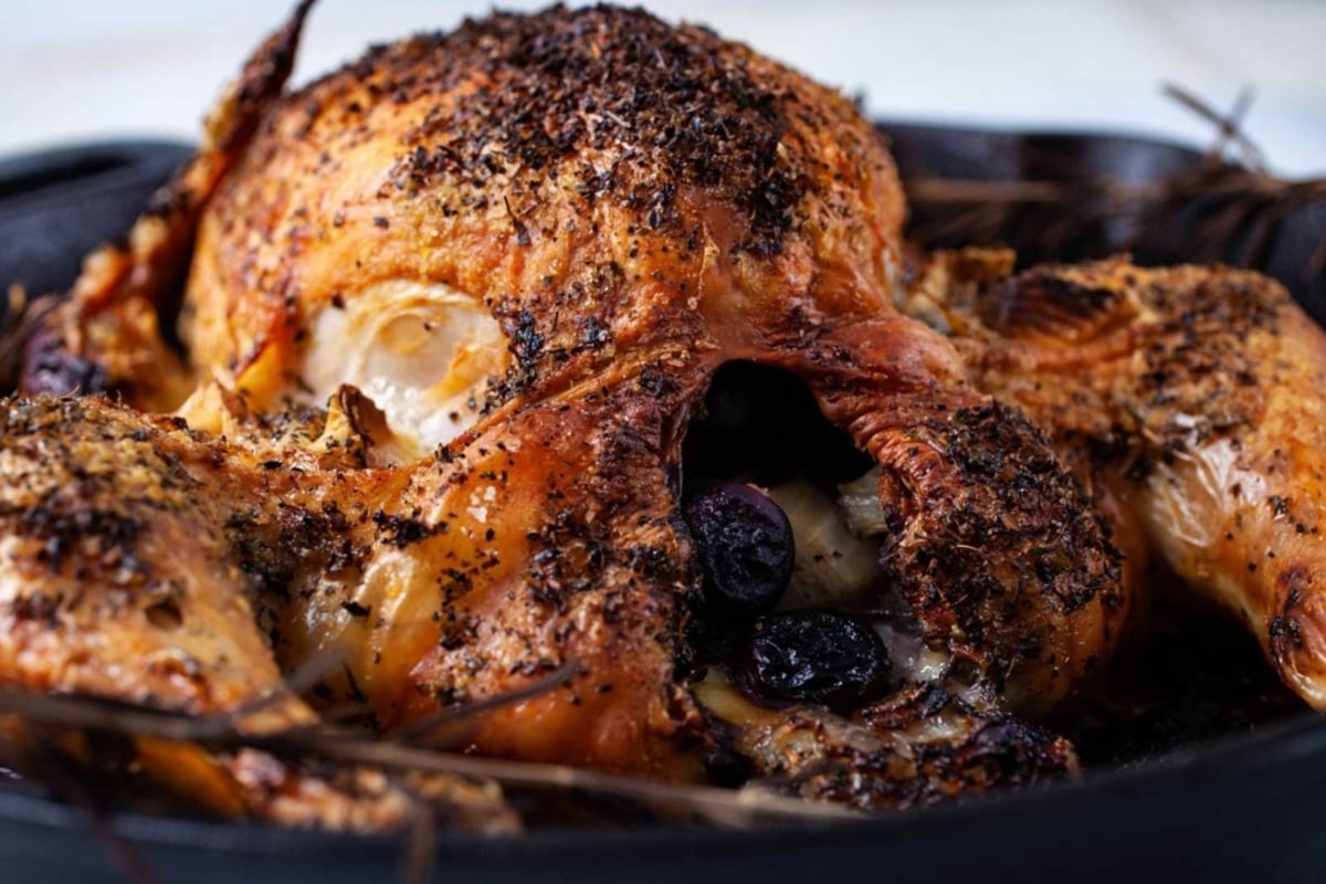 A savory roasted chicken with a tangy twist of blueberries cooked in a cast iron skillet - perfect for unforgettable New Year's dinners.