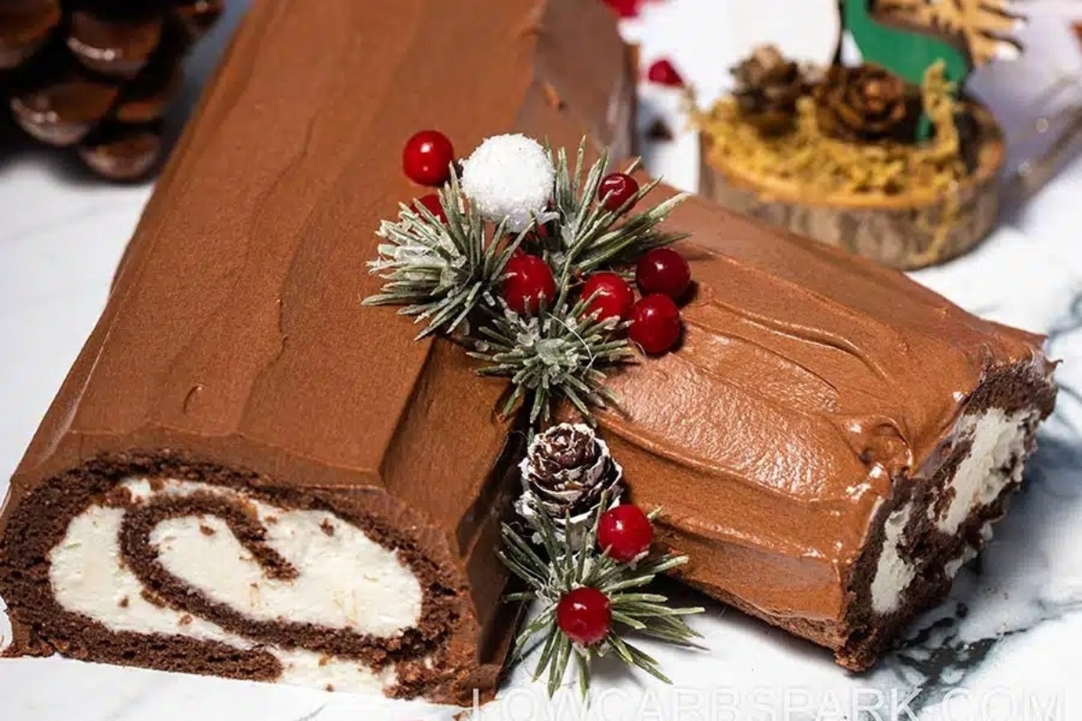 A chocolate rolled cake with icing and pine cones.