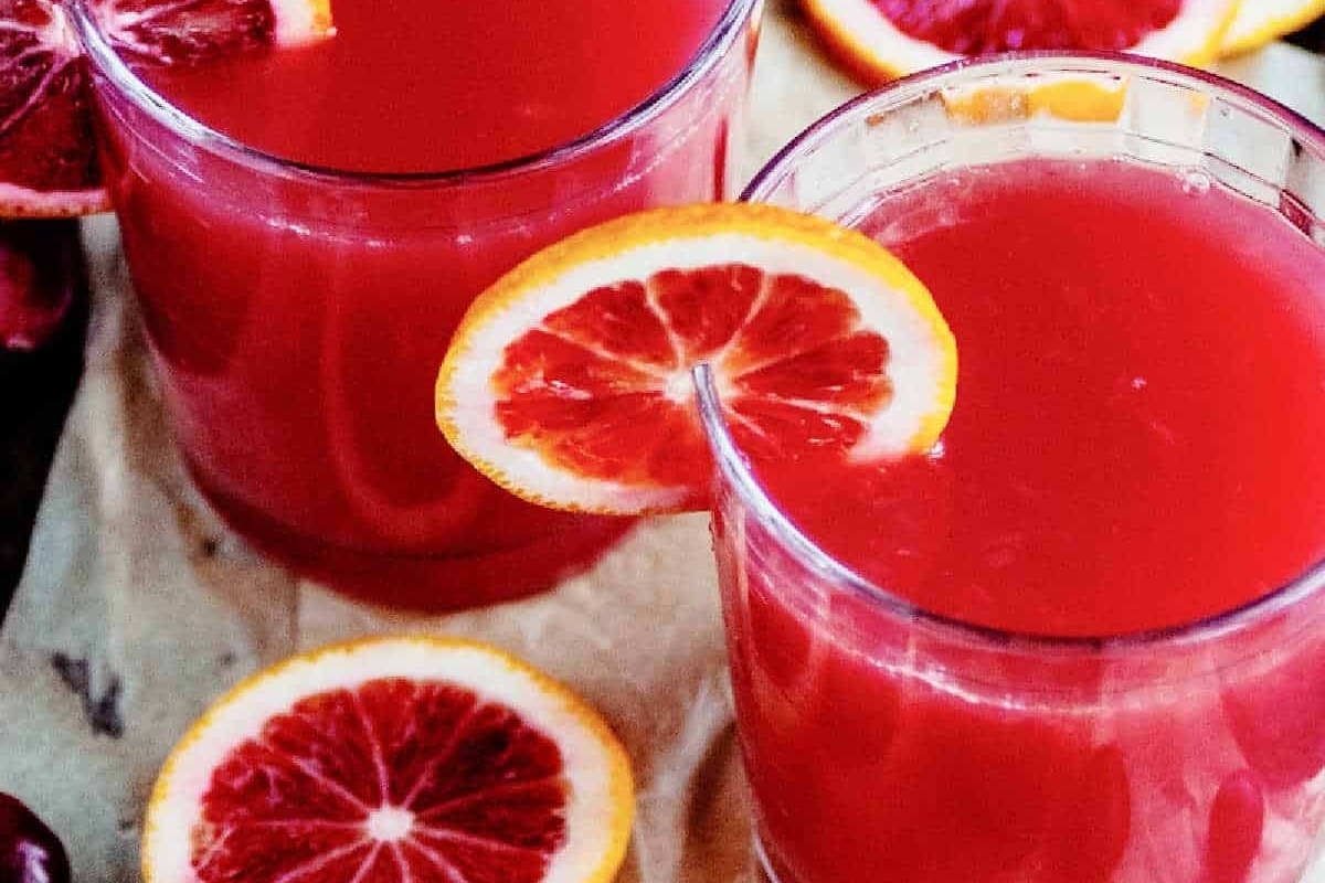 Two glasses of blood orange juice with orange slices, perfect for New Year's Eve cocktail ideas.