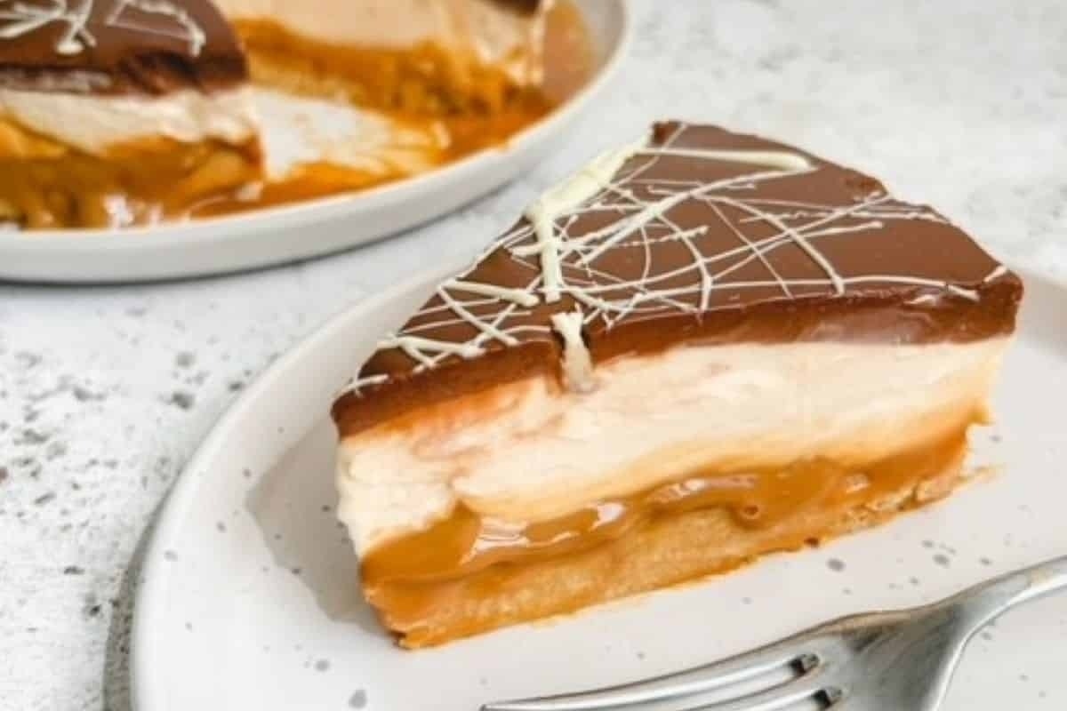 A slice of peanut butter cheesecake, a delicious no bake Christmas dessert, on a plate with a fork.