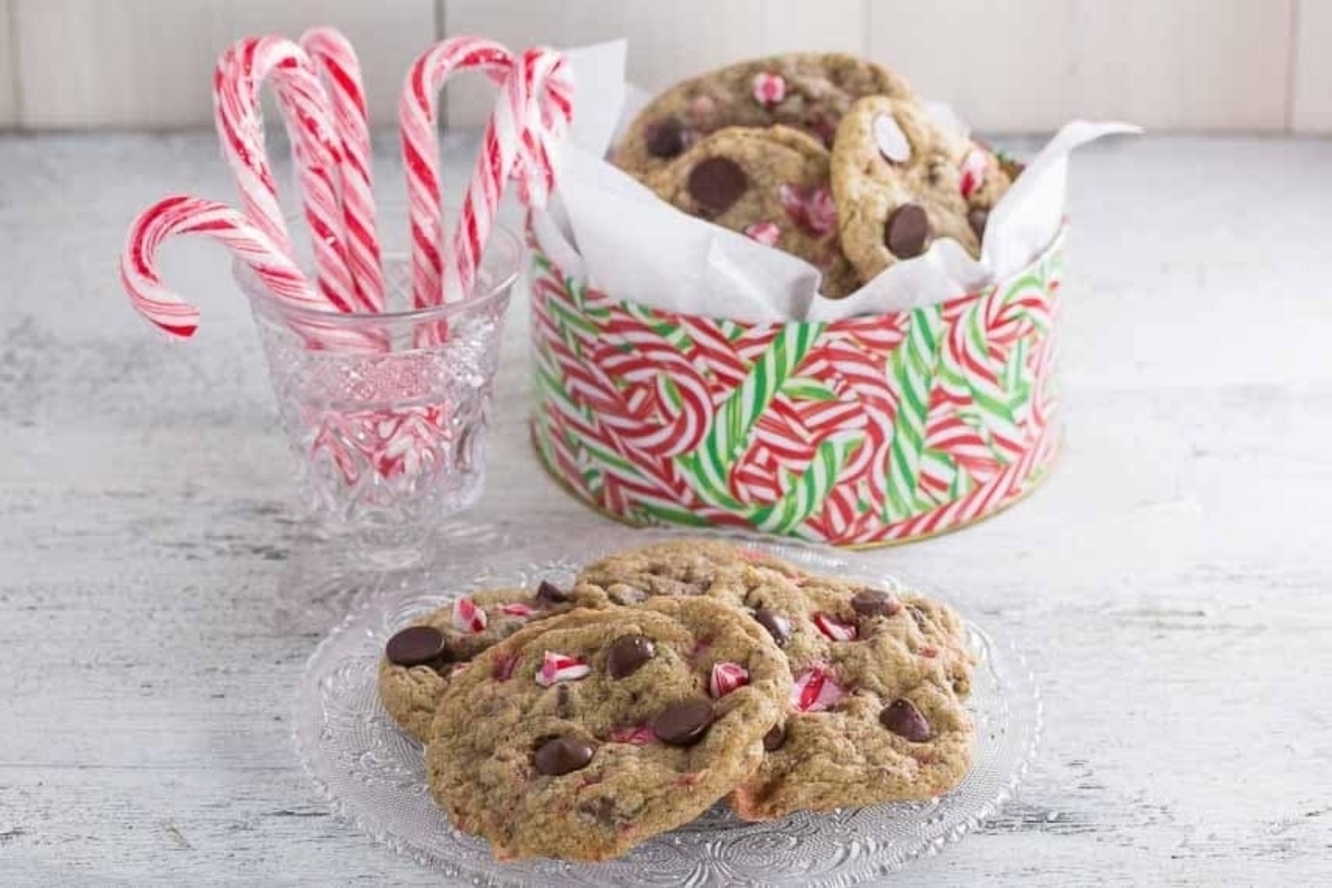 Peppermint cookies adorned with candy canes displayed on a plate.