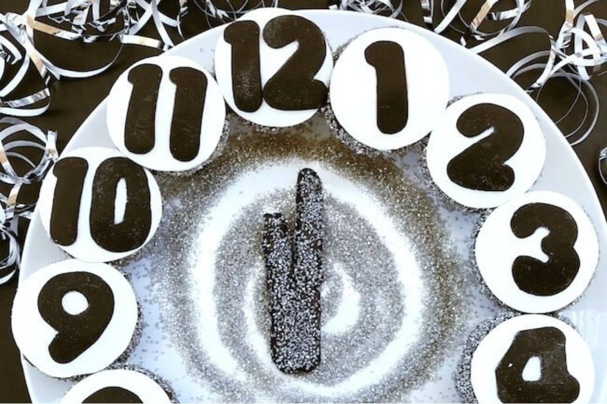 A festive cake with a clock on top, perfect for a New Year's eve party.