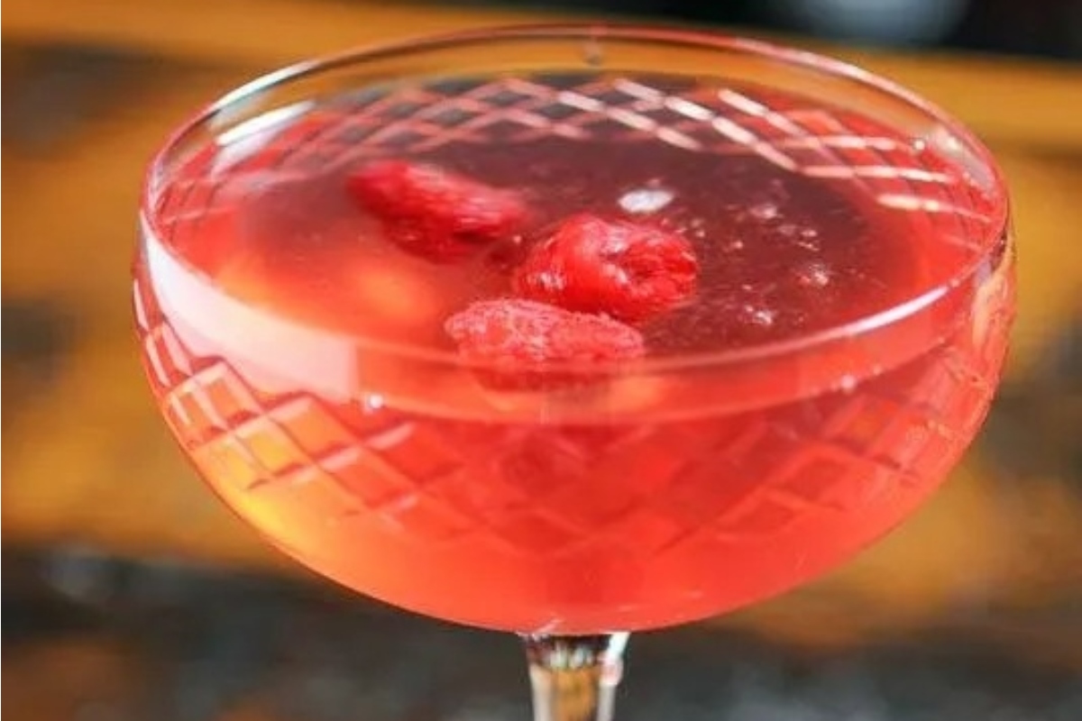 A **New Year's Eve cocktail** with raspberries in a glass.
