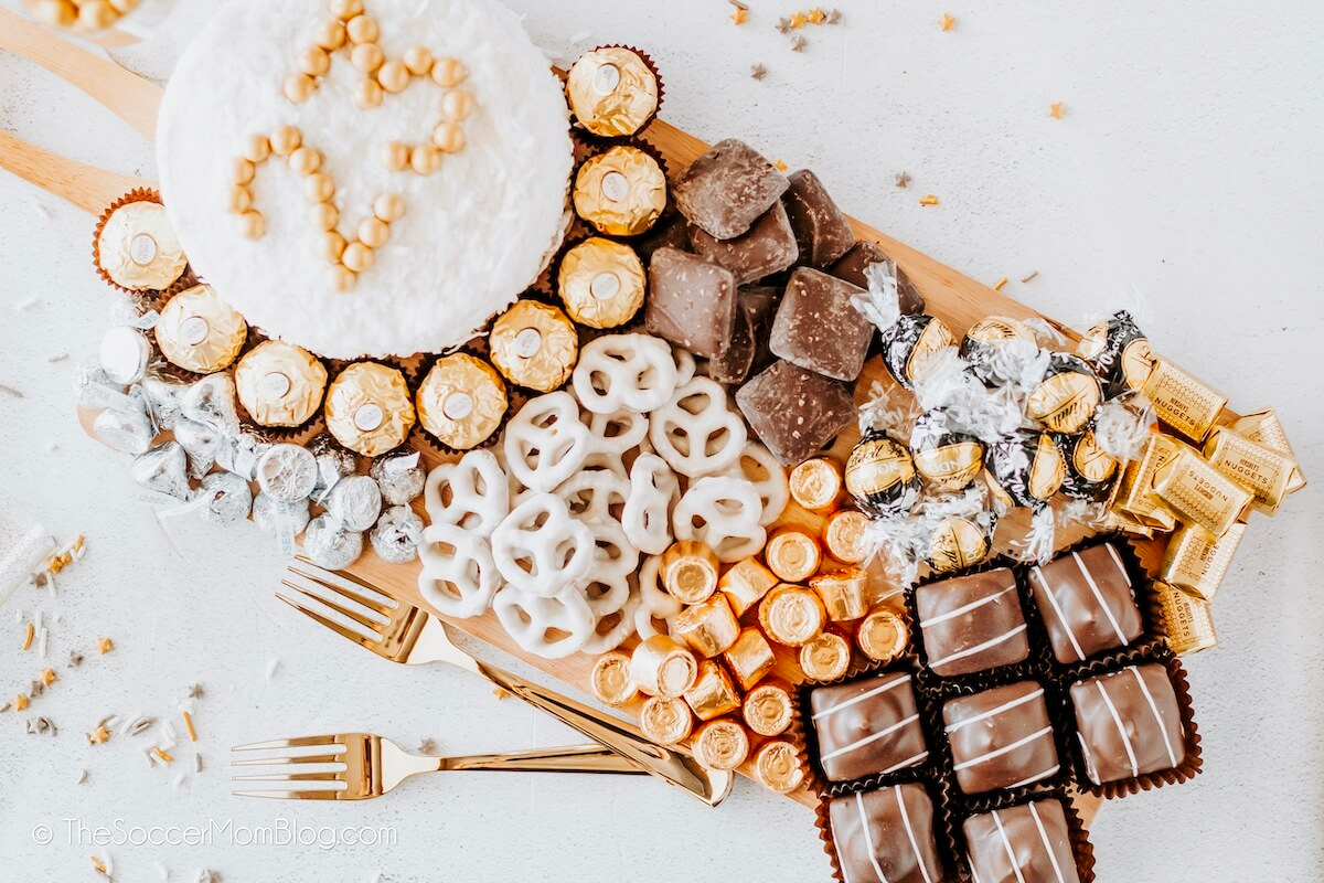 A festive platter of chocolates and candies on a wooden board, perfect for your New Year's Eve party.