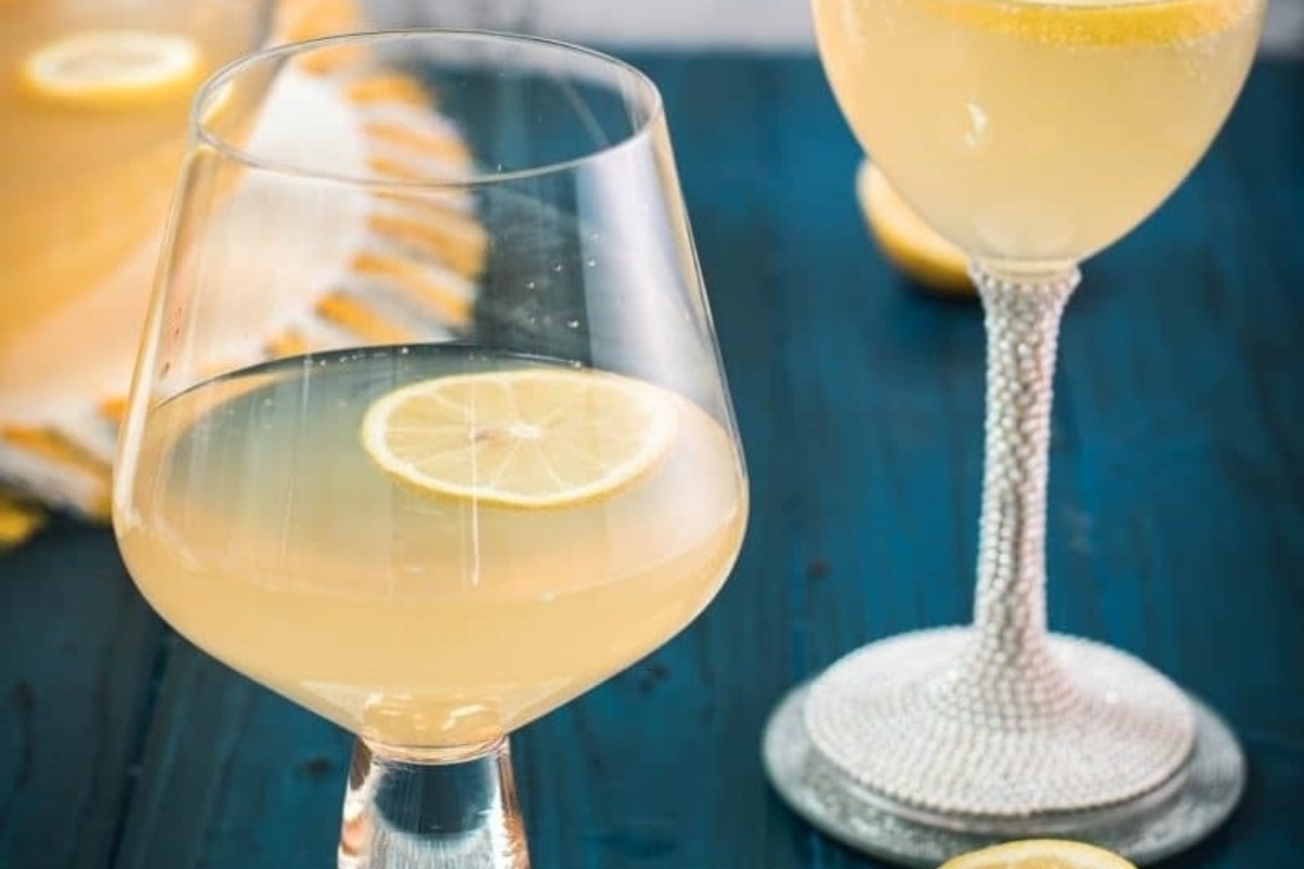 Two glasses of lemonade with a slice of lemon, perfect for a refreshing addition to your New Year's eve party.