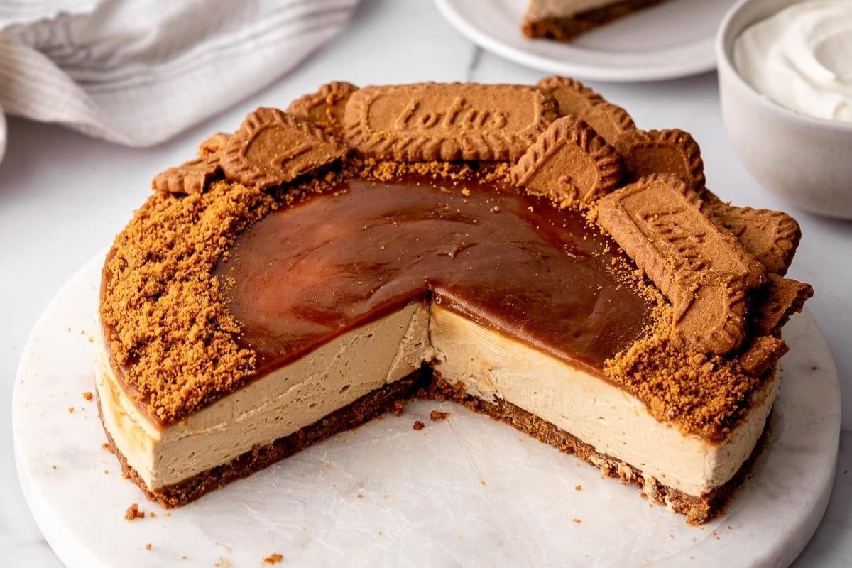 A delicious holiday cheesecake with a slice taken out of it.