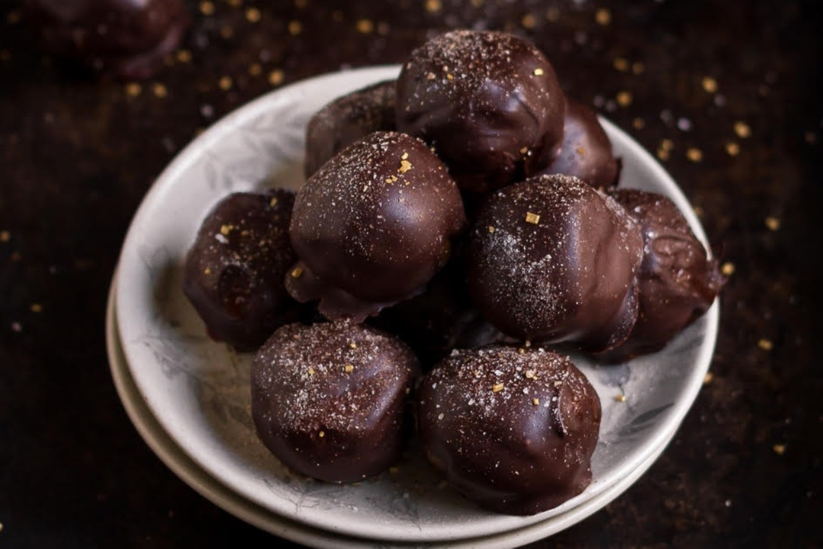 Decadent truffles drizzled in rich chocolate on a festive plate.
