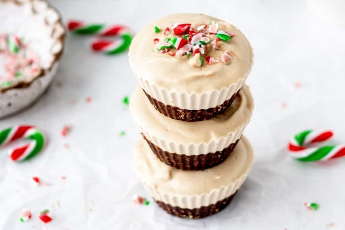 Three holiday chocolate candy cane cupcakes stacked on top of each other.