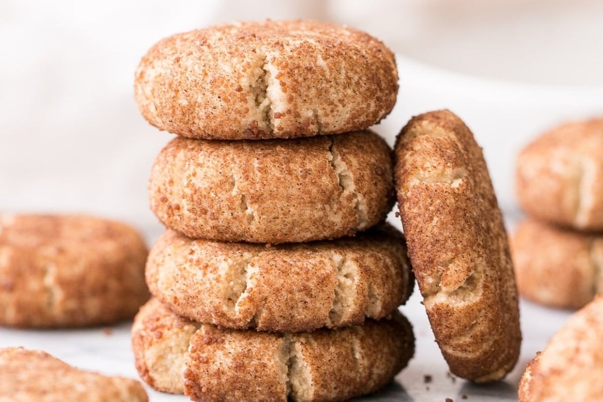 A stack of cinnamon sugar cookies, a few of which are freezable, on a white table.