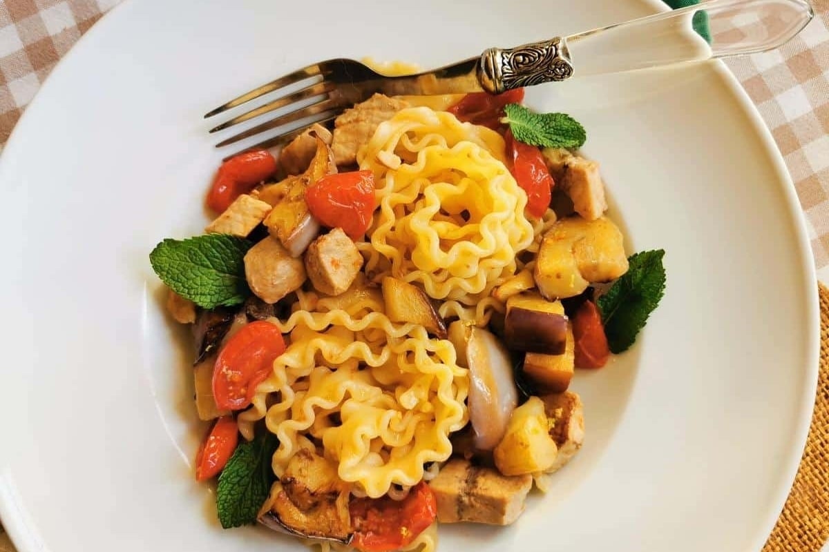 A feast of seven fishes featuring a plate of pasta with vegetables and a fork.