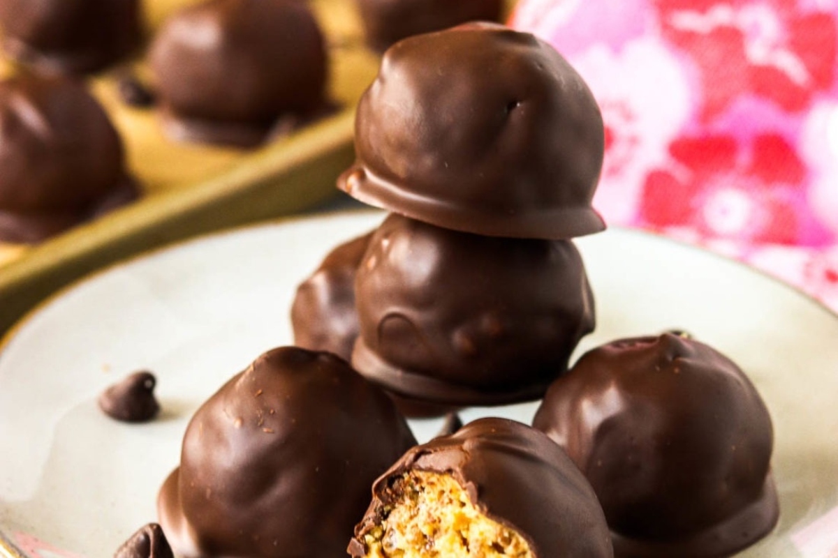 No bake chocolate peanut butter balls on a plate, perfect for Christmas desserts.