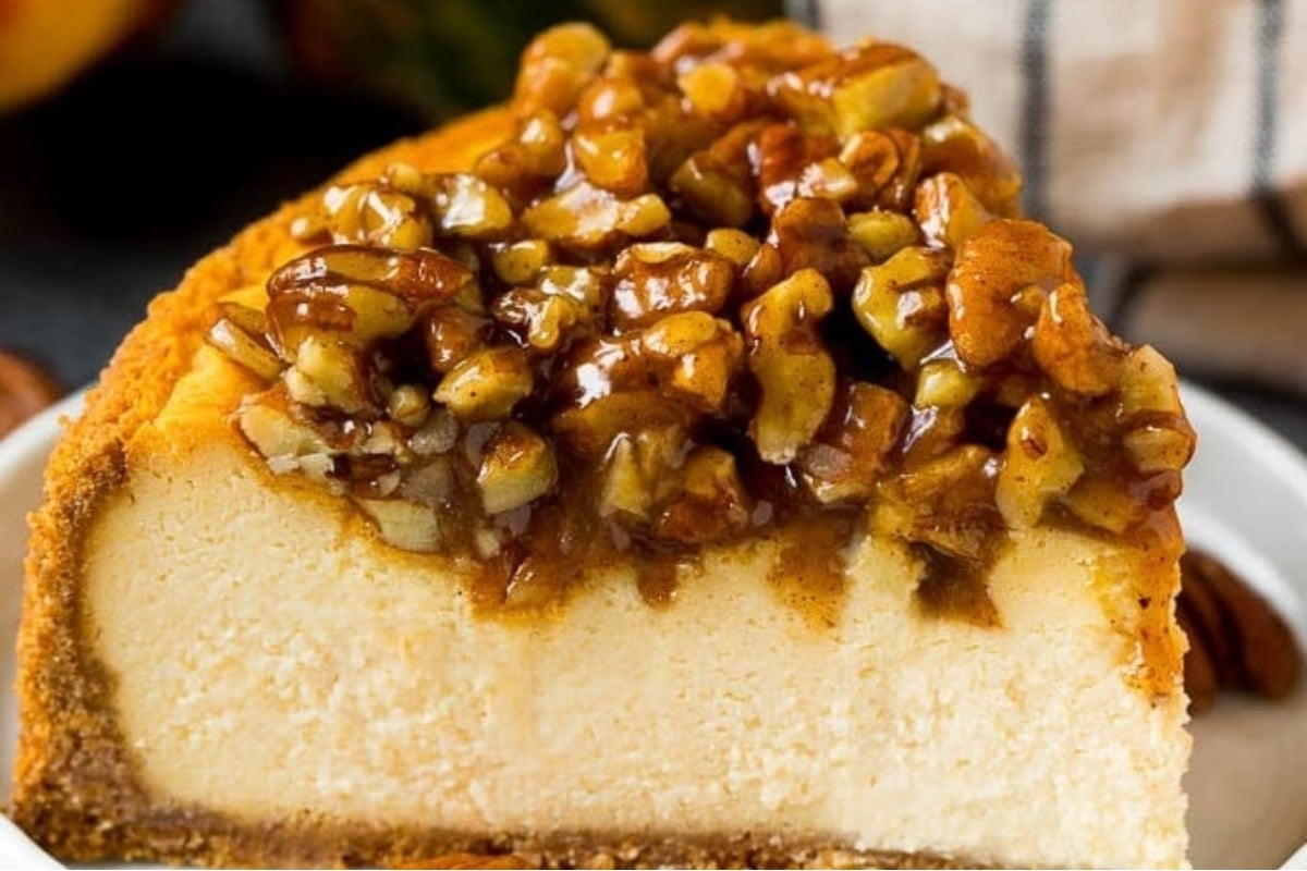 A slice of pumpkin cheesecake with pecans on a plate, perfect for holiday celebrations.