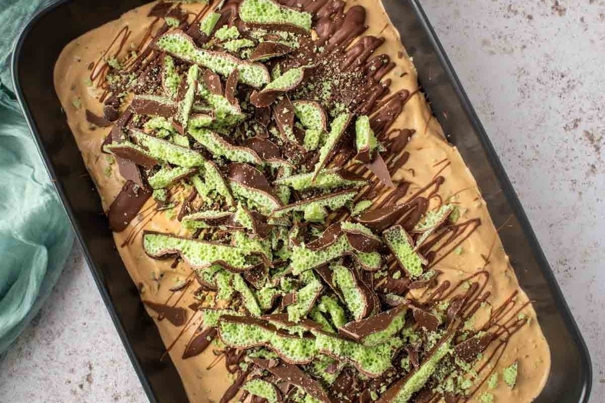 A baking pan with a brownie covered in chocolate and sprinkles. This delicious treat is perfect for peppermint lovers looking for new recipes to try.