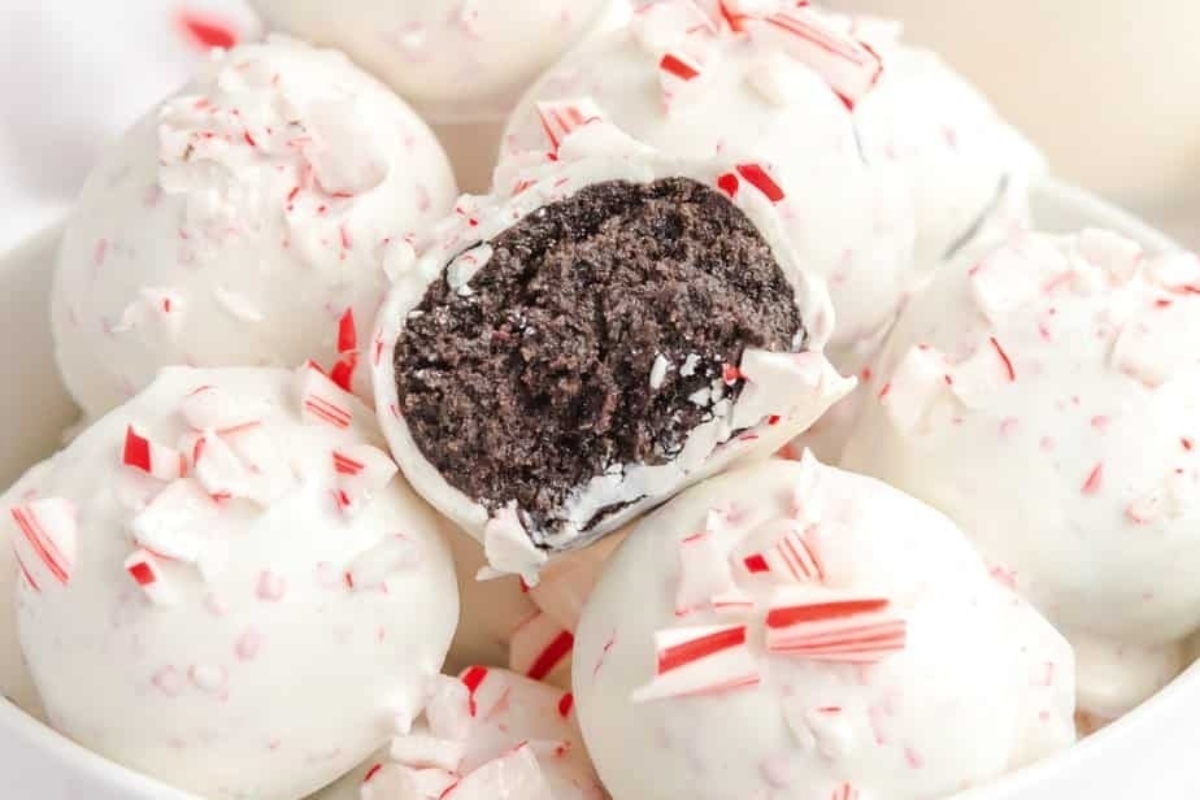 A white bowl with peppermint candy balls in it.