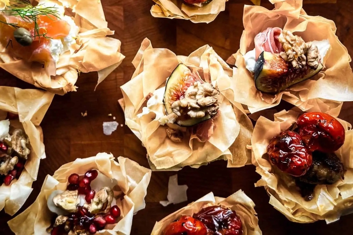 A delightful assortment of NYE appetizers neatly stored in paper bags on a tastefully decorated table.
