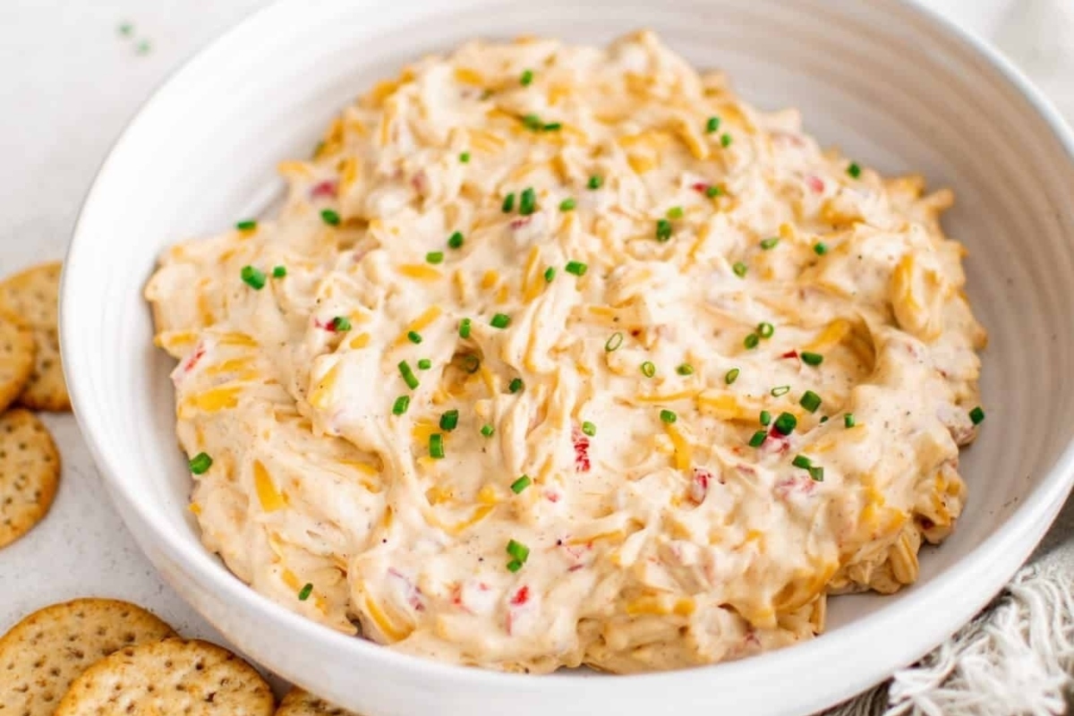 Cheesy NYE dip served in a white bowl with crackers.