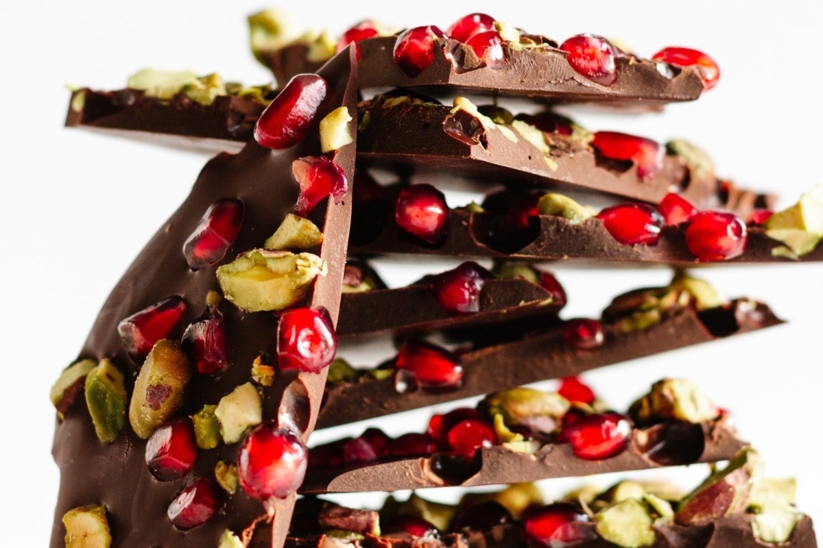 This festive Christmas bark recipe features a decadent chocolate bar adorned with juicy pomegranate seeds and crunchy pistachios.
