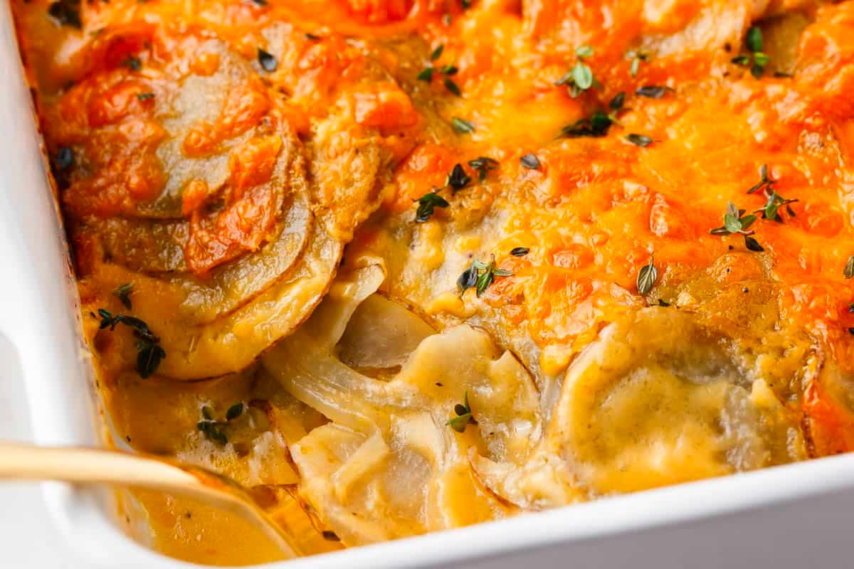 Cheesy potato casserole in a white dish, perfect for New Year's dinners.