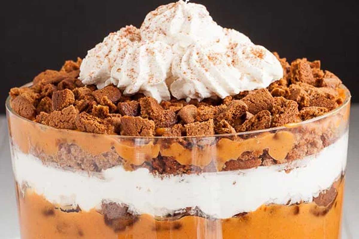 An indulgent Christmas trifle in a glass with whipped cream on top.