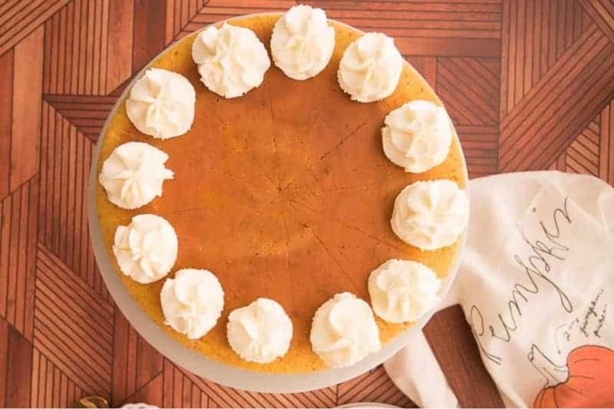 A holiday pumpkin pie with whipped cream on top.