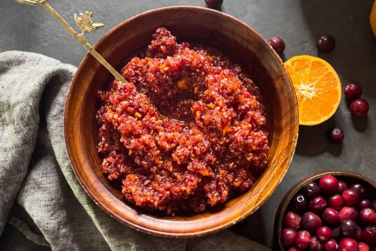 Make-ahead cranberry sauce in a bowl with oranges and cranberries, perfect for holiday dishes.