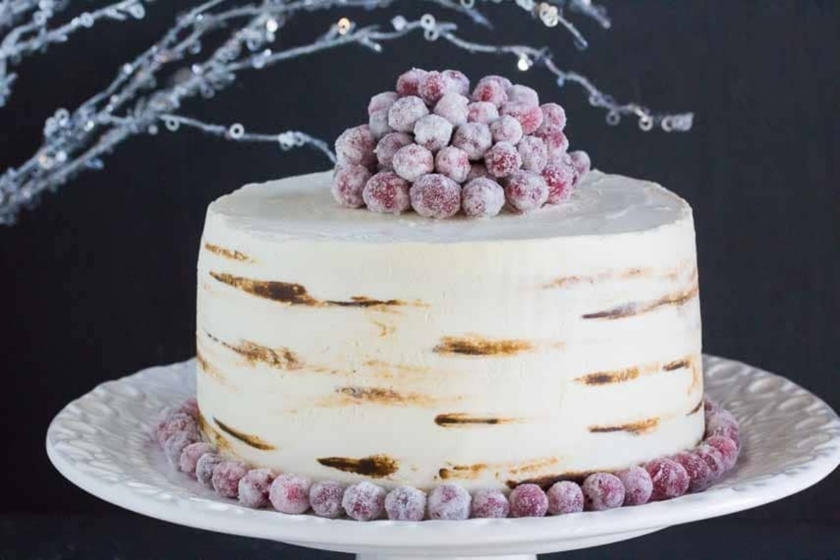 A festive white cake adorned with luscious berries, perfect for Christmas celebrations.