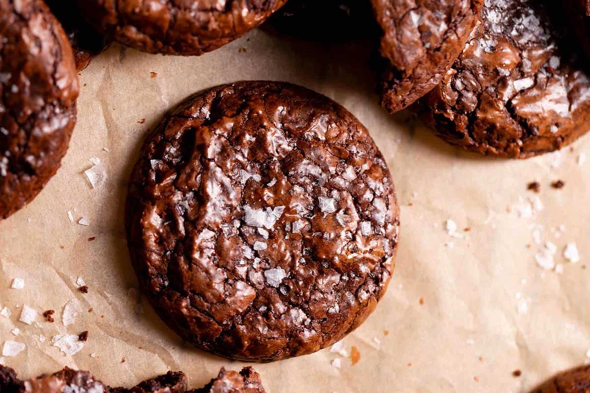Crinkle chocolate cookies with sea salt on a parchment paper.