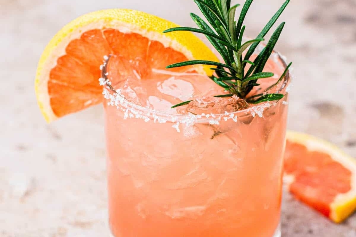 Celebrate New Year's Eve with a refreshing Grapefruit margarita garnished with a rosemary sprig.