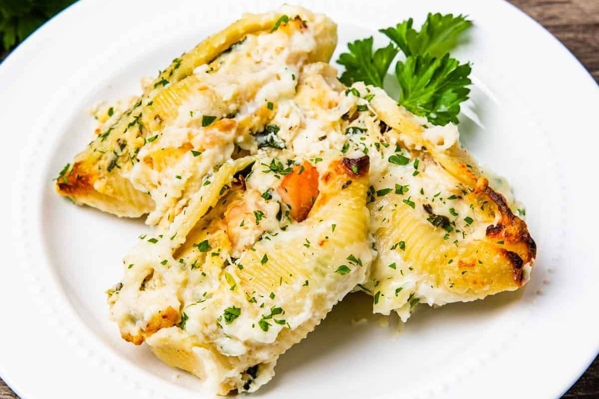 New Year's dinners: Stuffed shells with cheese and parsley on a white plate.
