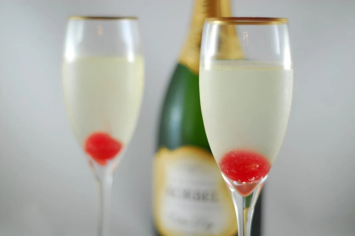 Two glasses of champagne with cherries in them, perfect for your New Year's eve party.